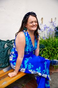 Lucy smiles in her sexy blue silk jumpsuit