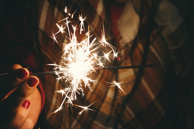 Picture of a sparker being held by a white woman's hand with red nail polish, it is dark, she is wearing a check scarf, This is meant to symbolize your libido.